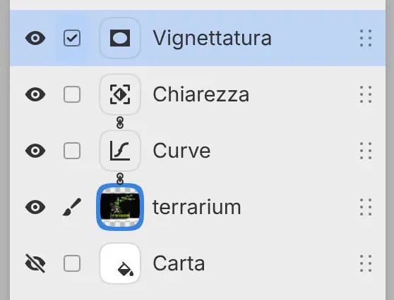 Il pannello Livelli con Curve e Chiarezza collegati alla foto del terrario, e un filtro Vignettatura su un livello proprio sopra di essi.